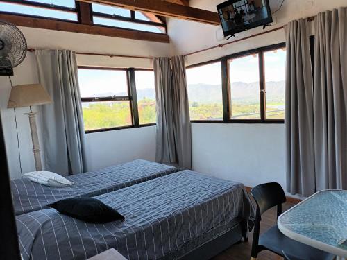 a bedroom with a bed and a television and windows at Cañada Al Lago in Villa Parque Siquiman
