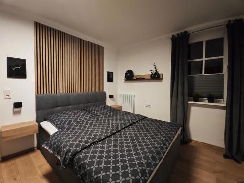 a bedroom with a bed with a black comforter at Ferienwohnung Platzhirsch für 2 - 4 Pers. in Winterberg