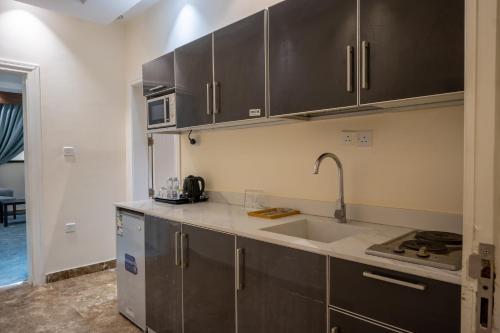 a kitchen with stainless steel cabinets and a sink at توجاردن النهضة - Tu jardin Al Nahda in Jeddah