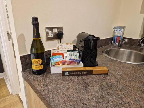 uma garrafa de vinho sentada num balcão ao lado de um lavatório em Tranquil Studio Apartment em Blandford Forum