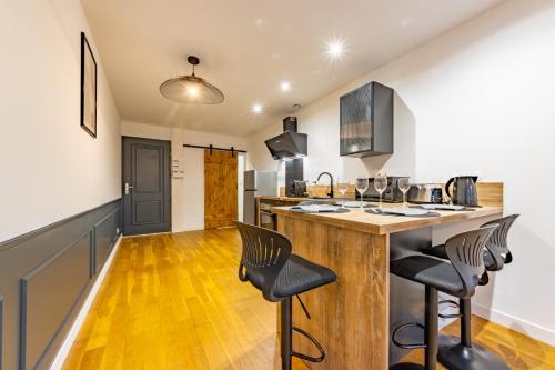 une cuisine avec un comptoir en bois et des chaises dans l'établissement Le beau Briand proche gare parking facile, à Montauban