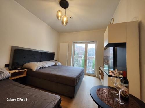 1 dormitorio con 1 cama, TV y mesa en Urocze Gniazdko w Centrum Poznania, en Poznan