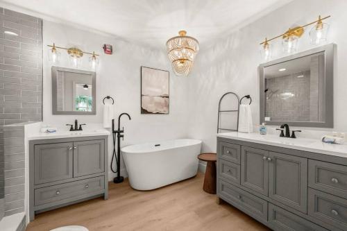 a bathroom with a tub and two sinks and a mirror at Luxurious Golf Condo W/ Resort Pool and Amenities! in Naples