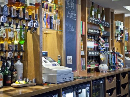 a bar with a cash register and bottles of alcohol at Burton Stone Inn - Free Parking on site in York