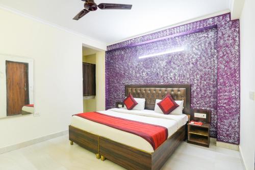 een slaapkamer met een bed en een paarse muur bij Hotel River Front in New Delhi