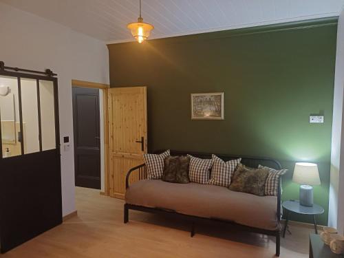 a living room with a couch and a green wall at Dwór pod Sosnami Kaszuby in Ostrzyce