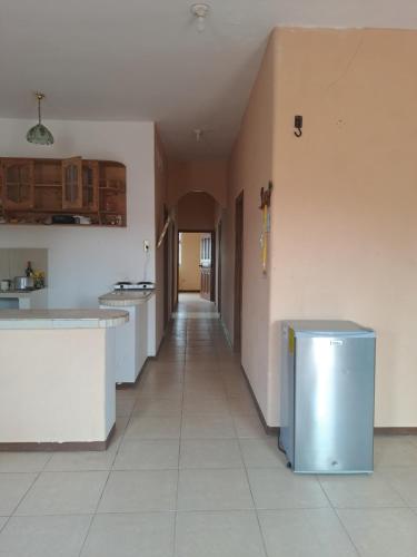 a kitchen with white counters and a long hallway at Hospedaje Playa y Arena in Playas