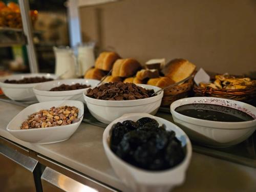 a buffet with bowls of food on a table at Pensiunea Viktoria in Băile Tuşnad