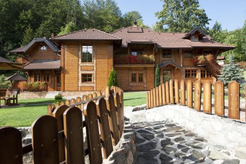 una valla de madera frente a una casa en Zlatibor Resort & Spa en Zlatibor