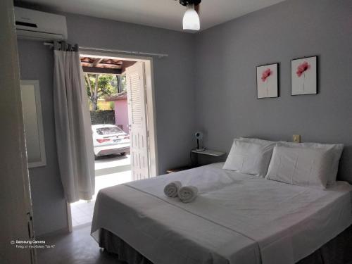 1 dormitorio con 1 cama con 2 toallas en PRAIA DE TAPERAPUAN - FLAT EM CONDOMINIO A 300 METROS DA PRAIA., en Porto Seguro