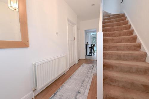 a staircase in a home with white walls and wood floors at Home from home Retreat in The Hyde