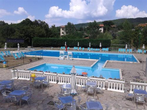 a large swimming pool with chairs and tables at Appartamenti Capenti in Arcidosso