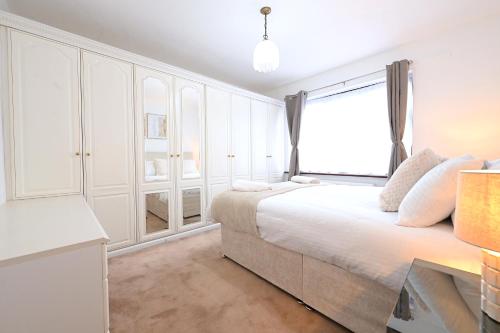 a white bedroom with a large bed and a window at Home from home Retreat in The Hyde