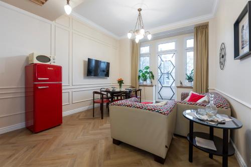 sala de estar con nevera roja y sillas en Elegancki Apartament Polonia Residence z widokiem na centrum Łodzi i prywatnym parkingiem, en Łódź