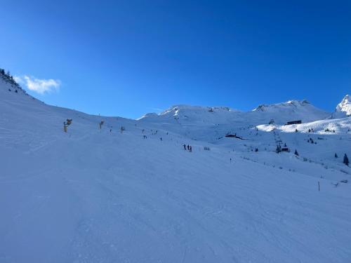 a group of people skiing down a snow covered slope at Apartment Hava in Bad Hofgastein