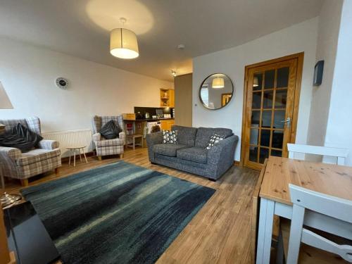 a living room with a couch and a table at Rose Cottage, Fishertown in Nairn