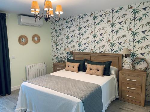 1 dormitorio con 1 cama con papel pintado tropical en Apartamentos Buganvilla, en Alhama de Aragón