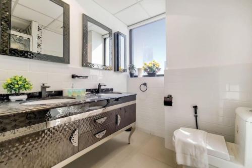 a bathroom with two sinks and a mirror at Jbr Sea View Captivating 4-Bed Apartment in Dubai in Dubai
