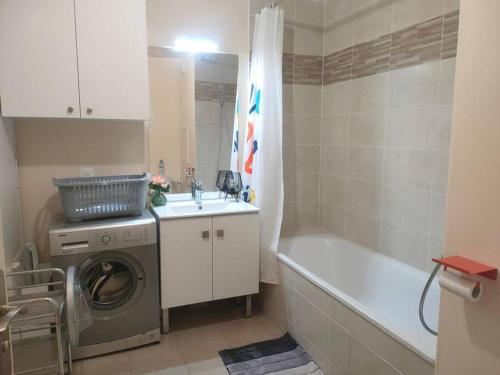 a bathroom with a washing machine and a bath tub at Appartement in Villejuif (M 7) with free parking in Villejuif