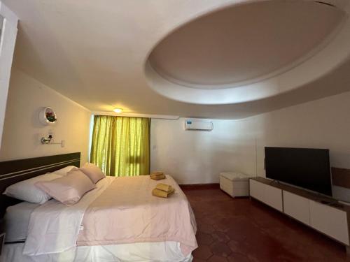 a bedroom with a large bed and a flat screen tv at Casa Barrio Bombal in Mendoza