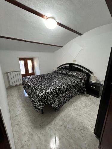1 dormitorio con 1 cama con manta blanca y negra en The Refuge of Angels, en Pizzoferrato