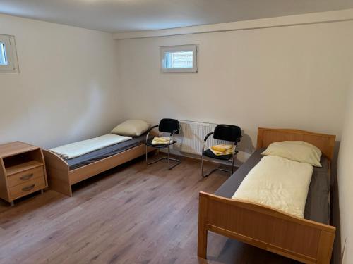 a bedroom with a bed and two chairs in it at Souterrainwohnung Offenburg in Offenburg