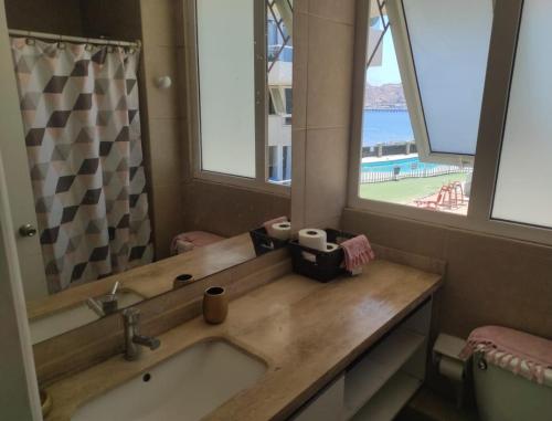 a bathroom with a sink and a large mirror at Duplex la herradura in Coquimbo
