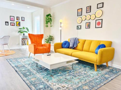 a living room with a yellow couch and two orange chairs at Groovy Getaway Retro Vibes in North Park, SD in San Diego