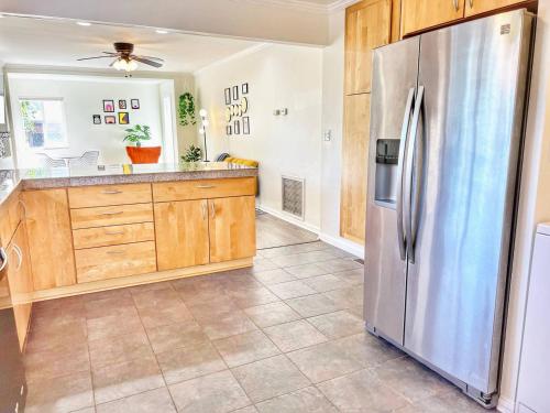 a kitchen with a stainless steel refrigerator and wooden cabinets at Groovy Getaway Retro Vibes in North Park, SD in San Diego
