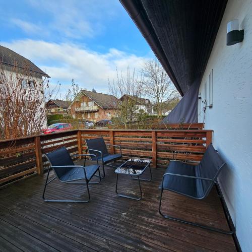 巴特貝勒堡的住宿－Fewo am premium Wanderort，木制甲板上的三把椅子和一张桌子