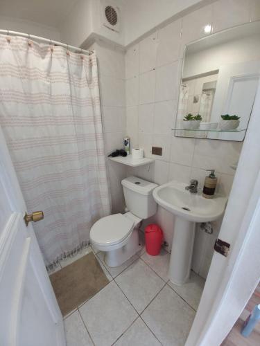 a white bathroom with a toilet and a sink at Excelente ubicación in Concón