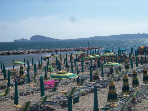 a bunch of chairs and umbrellas on a beach at Hotel Tirreno Formia in Formia