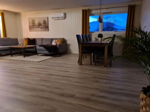 Tromsø stunning Luxury apart B في ترومسو: غرفة معيشة مع أريكة وطاولة