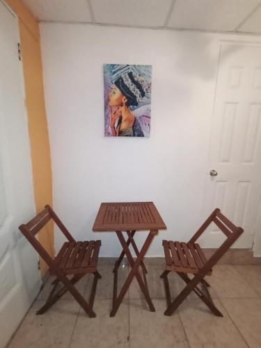 two chairs and a table and a picture on the wall at Belo Bay Apartment Hotel in Portobelo