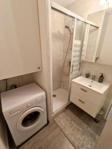 une petite salle de bains avec un lave-linge et un lavabo dans l'établissement Appartement Centre port 4 pers Cap d'Agde, au Cap d'Agde