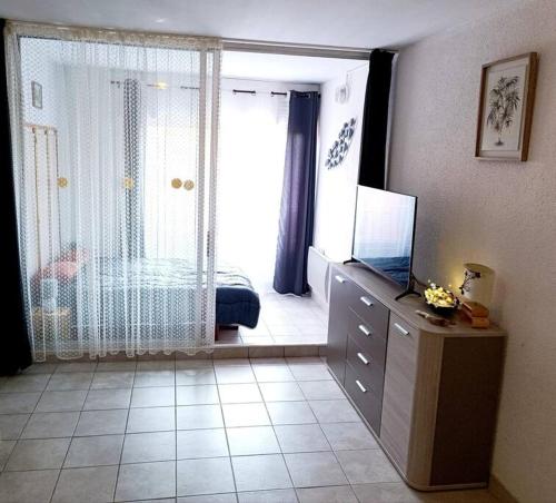 Habitación con dormitorio y tocador con TV. en Appartement Centre port 4 pers Cap d'Agde en Cap d'Agde