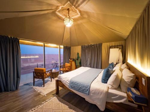 1 dormitorio con 1 cama y vistas al desierto en Starry Domes Desert Camp II, en Badīyah