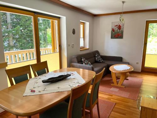 sala de estar con mesa y sofá en Chalet Harmony Rogla - apartment, en Zreče