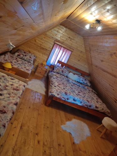 an attic bedroom with two beds and a window at Kuća za odmor Antonija in Gospić