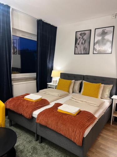 a bedroom with a large bed with yellow pillows at Noah Longstay Borås in Borås