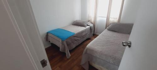 a small room with two beds and a window at Lindo departamento central in Ovalle