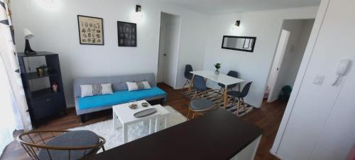 a living room with a blue couch and a table at Lindo departamento central in Ovalle