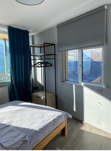 a bedroom with a bed and two windows at 2-room Apartment NFT Gudauri Penta 701 in Gudauri