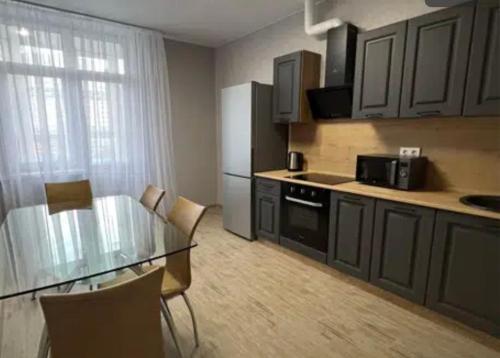 een keuken met een glazen tafel en een koelkast bij VIP apart 787 in Tbilisi City