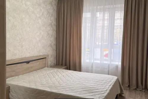 een slaapkamer met een bed en een groot raam bij VIP apart 787 in Tbilisi City