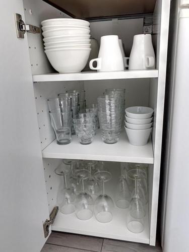 a cabinet filled with dishes and cups and bowls at Mazet NiMiSa in Marseillan