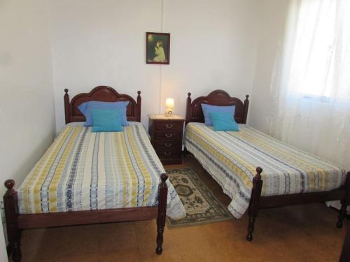 dos camas sentadas una al lado de la otra en un dormitorio en Casa da Fonte dos Castanheiros en Estreito da Calheta