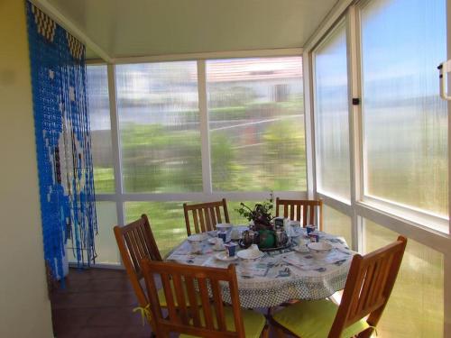mesa de comedor con sillas, mesa y ventana en Casa da Fonte dos Castanheiros en Estreito da Calheta