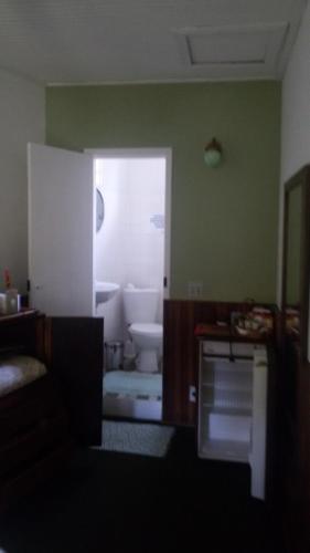 a bathroom with a toilet in a room with green walls at Chales Joia Rara Dos Gnomos in Visconde De Maua