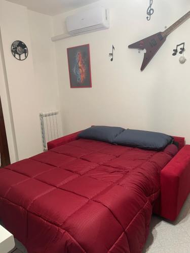 莫利亞諾威尼托的住宿－House of music near venice，卧室内的红色床和红色棉被